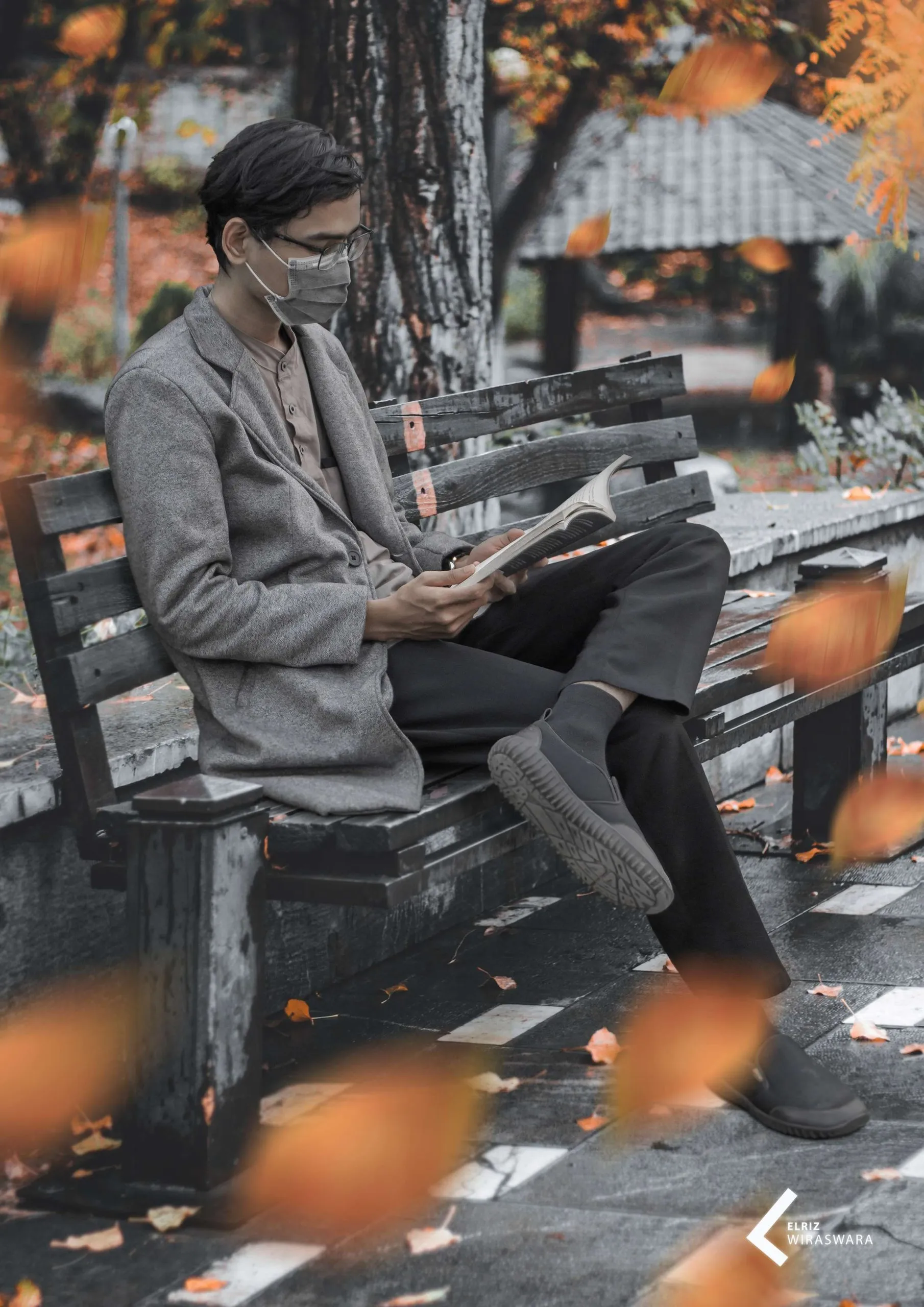 Elriz Wiraswara reading a book on a park bench